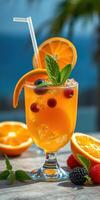 Refreshing citrus cocktail served with fresh berries at a beachside setting during sunset photo