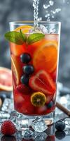 Refreshing fruit beverage with ice and mint served in a tall glass showcasing vibrant colors photo