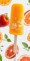 Colorful orange popsicle surrounded by fresh fruits and vegetables on a bright background photo