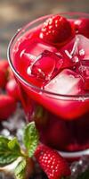 Refreshing raspberry beverage with ice and mint garnishing on a wooden surface photo