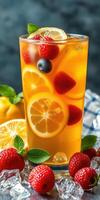 Refreshing fruit beverage garnished with raspberries, blueberries, and lemon slices in a tall glass photo
