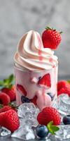 Delicious dessert featuring soft-serve strawberry ice cream topped with fresh raspberries and blueberries in a glass cup photo