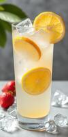 Refreshing lemonade with lemon slices and strawberries on a summer day photo