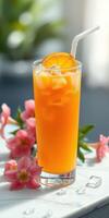 Refreshing orange beverage with ice and flower garnish served in a tall glass photo