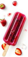 Colorful fruit popsicle surrounded by fresh strawberries and ice cubes on a bright background photo