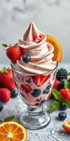 Delicious berry swirl frozen dessert topped with fresh strawberries and orange slice served in a glass cup photo