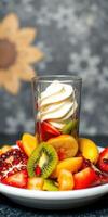 Fresh fruit dessert with cream served in a glass, full of vibrant colors and rich flavors photo