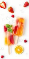 Colorful fruit popsicles surrounded by fresh berries and ice on a white background photo