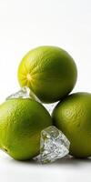 Fresh limes and ice cubes arranged on a clean surface with bright lighting photo