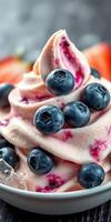 Delicious frozen yogurt topped with fresh blueberries and vibrant fruit swirls served in a bowl photo
