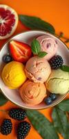 Colorful ice cream bowl featuring various flavors and fresh fruits displayed on a vibrant orange background photo