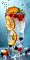 Refreshing summer beverage served in a tall glass with ice, fruits, and mint leaves on a blue background photo