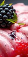 Fresh dessert featuring blackberries and a mint leaf on a vibrant pink background during a sunny afternoon photo