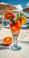 Refreshing tropical cocktail garnished with fruits on a sunny beach photo