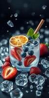 Refreshing summer beverage with fruits and ice cubes in a stylish glass on a dark background photo