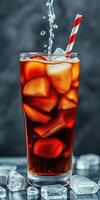 Refreshing fizzy drink with ice cubes and a striped straw on a dark background photo