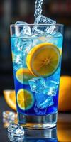 Refreshing blue lemonade drink with lemon slices and ice cubes on a summer day photo