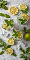 Refreshing mint and citrus beverages on a gray tabletop with ice and lime slices photo