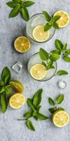 Refreshing lemon mint drinks served with fresh ingredients on a textured surface photo