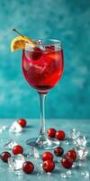Vibrant fruit cocktail garnished with lemon slice served in a clear glass on a teal background photo
