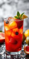 Refreshing fruit cocktail served in a chilled glass garnished with mint and lemon slice on a dark table photo