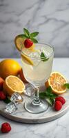 Refreshing lemon mint beverage garnished with fresh raspberries and lemon slices on marble surface photo