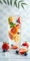 Refreshing summer beverage filled with fresh fruits and ice garnished with mint leaves photo