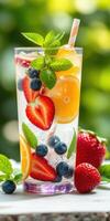Refreshing summer drink with fresh fruits and mint served in a clear glass photo