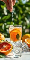 Refreshing citrus drink with ice and fresh slices on a bright sunny day photo