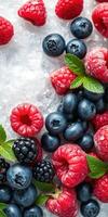 Fresh berries and mint leaves arranged on ice for a vibrant summer dessert or snack photo