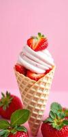 Delicious strawberry soft serve in a waffle cone with fresh strawberries and mint against a pink backdrop photo