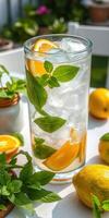Refreshing summer citrus drink with mint and ice in a garden setting on a sunny day photo