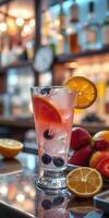Refreshing fruity cocktail served in a glass with summer fruits on a bar counter photo