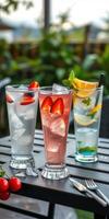 Refreshing cocktails served on a table in an outdoor setting with greenery in the background photo