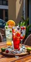 Refreshing summer cocktails served on a wooden table outside a bustling cafe photo