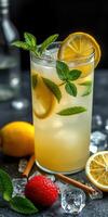 Refreshing mint lemonade served in a tall glass with lemon slices and mint leaves on a dark background photo