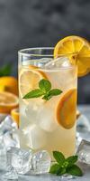 Refreshing lemon drink with mint served over ice in a clear glass photo