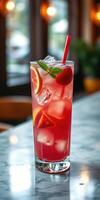 Refreshing fruity drink garnished with lemon and mint on a marble countertop in a cozy cafe setting photo