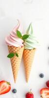Soft serve ice cream cones topped with mint leaves and fresh fruits on a light background photo