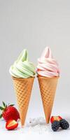Ice cream cones with mint green and strawberry pink swirls next to fresh strawberries and berries photo