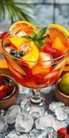 Colorful fruit cocktail topped with mint and served in a glass bowl during a summer gathering photo