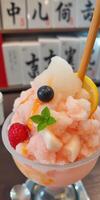 Refreshing dessert featuring shaved ice topped with fruits and syrup at a Japanese cafe during summer photo