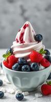 Delicious berry swirl soft serve topped with fresh strawberries and blueberries in a bowl photo