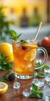 Refreshing iced tea with lemon and mint served in a clear glass on a wooden table surrounded by fresh fruit photo