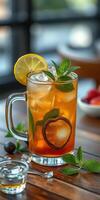 Refreshing iced tea with lemon and mint garnished on a wooden table in a cozy cafe setting photo