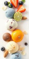 Assorted ice cream scoops arranged with fresh fruits and nuts on a white surface for a colorful dessert display photo