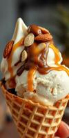 Enjoying a delicious ice cream cone topped with caramel drizzle and nuts on a sunny day photo