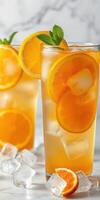Refreshing citrus drinks served in tall glasses with ice and garnished with mint leaves photo