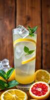Refreshing citrus drink with mint and ice garnished with lemon and a hint of mint on a wooden background photo