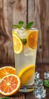 Refreshing citrus drink garnished with mint and ice on a rustic wooden table photo